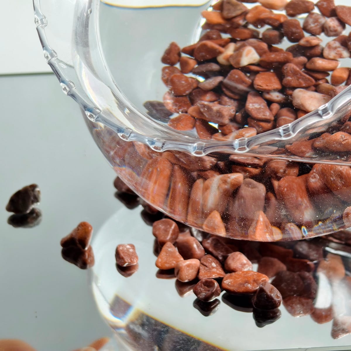 Red garden gravel displayed in a decorative glass bowl