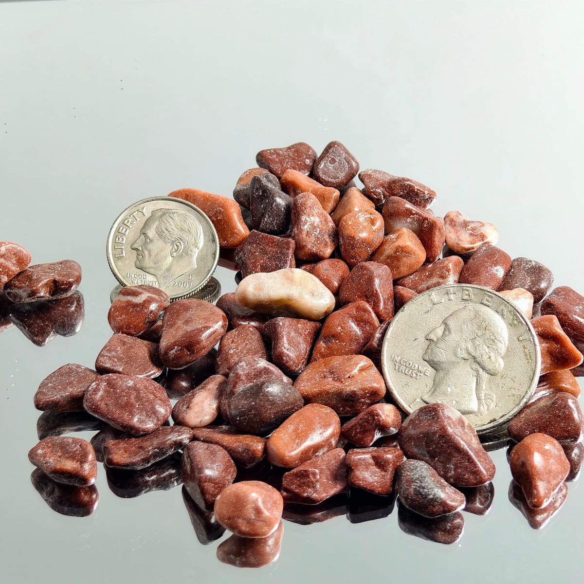 Landscape gravel in mixed red and tan tones with size reference